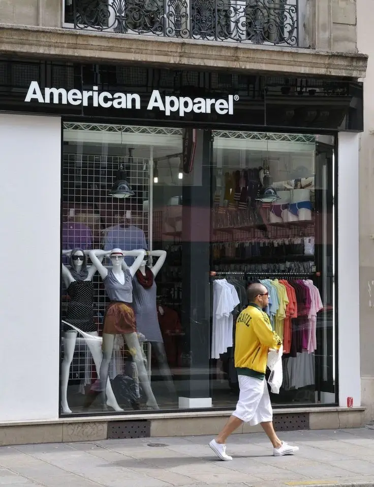 Façade d'une boutique American Apparel avec une typographie Helvetica et une identité visuelle minimaliste.