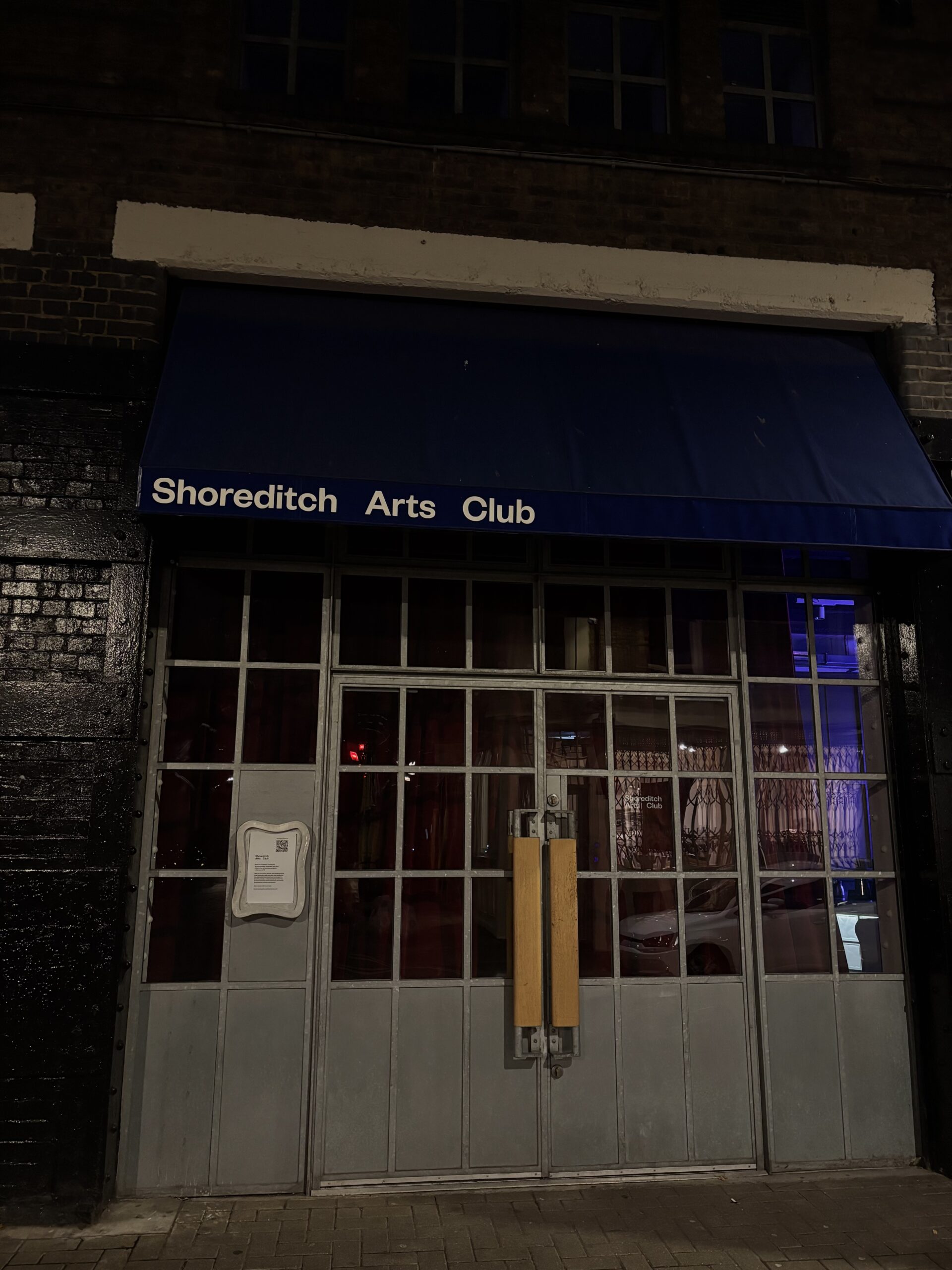 Façade bleu nuit du Shoreditch Arts Club à Shoreditch, Londres, avec une identité visuelle minimaliste et une typographie blanche.