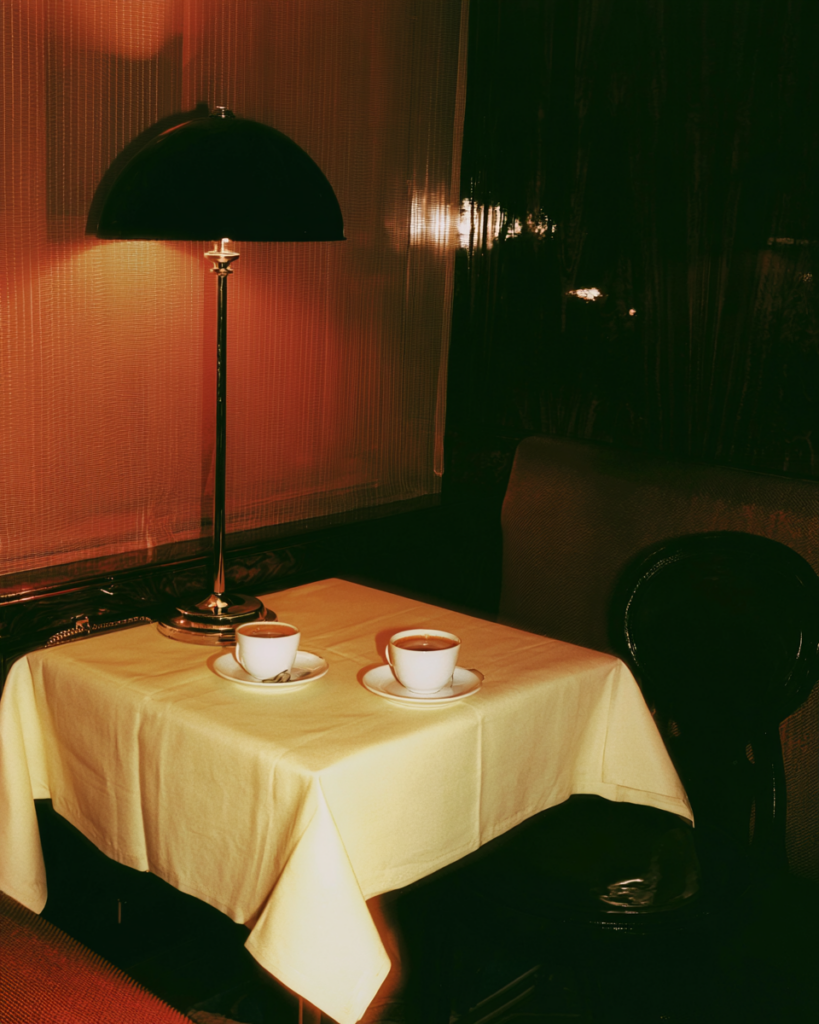 Table de restaurant sombre éclairée par une lampe avec deux cafés