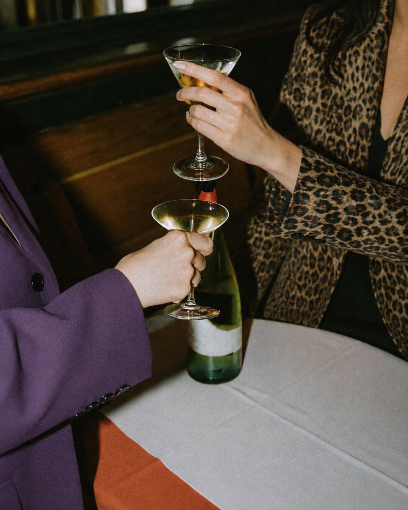 Deux personnes trinquant avec des cocktails dans le salon d’un hôtel