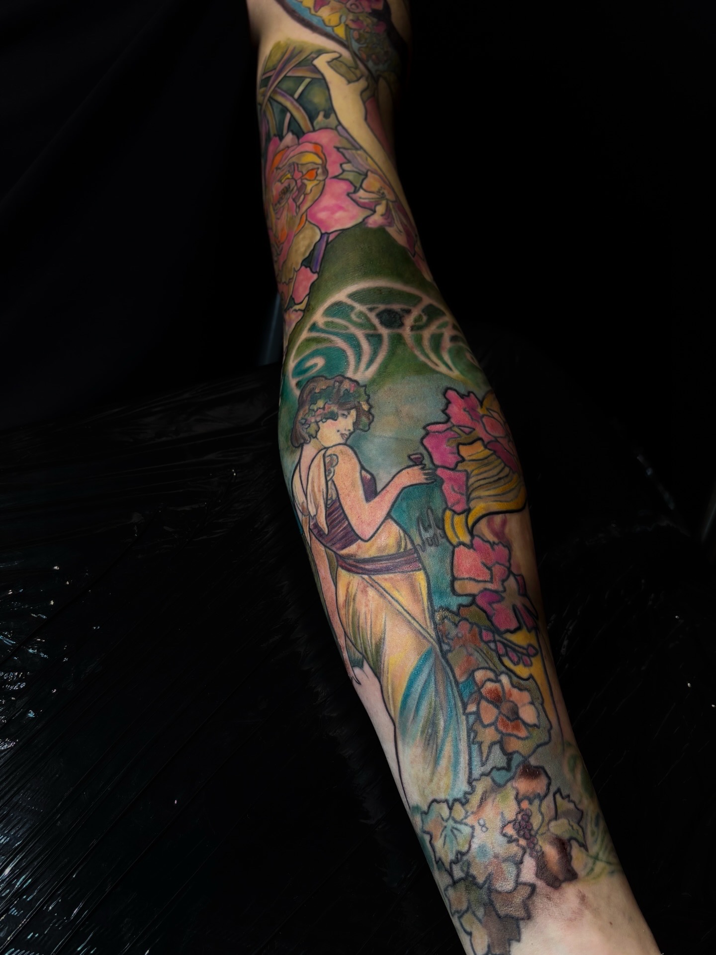 Détail du bras de Thomas tatoué en couleur par Tamara Chaudesaigues, inspiré des compositions d’Alphonse Mucha.